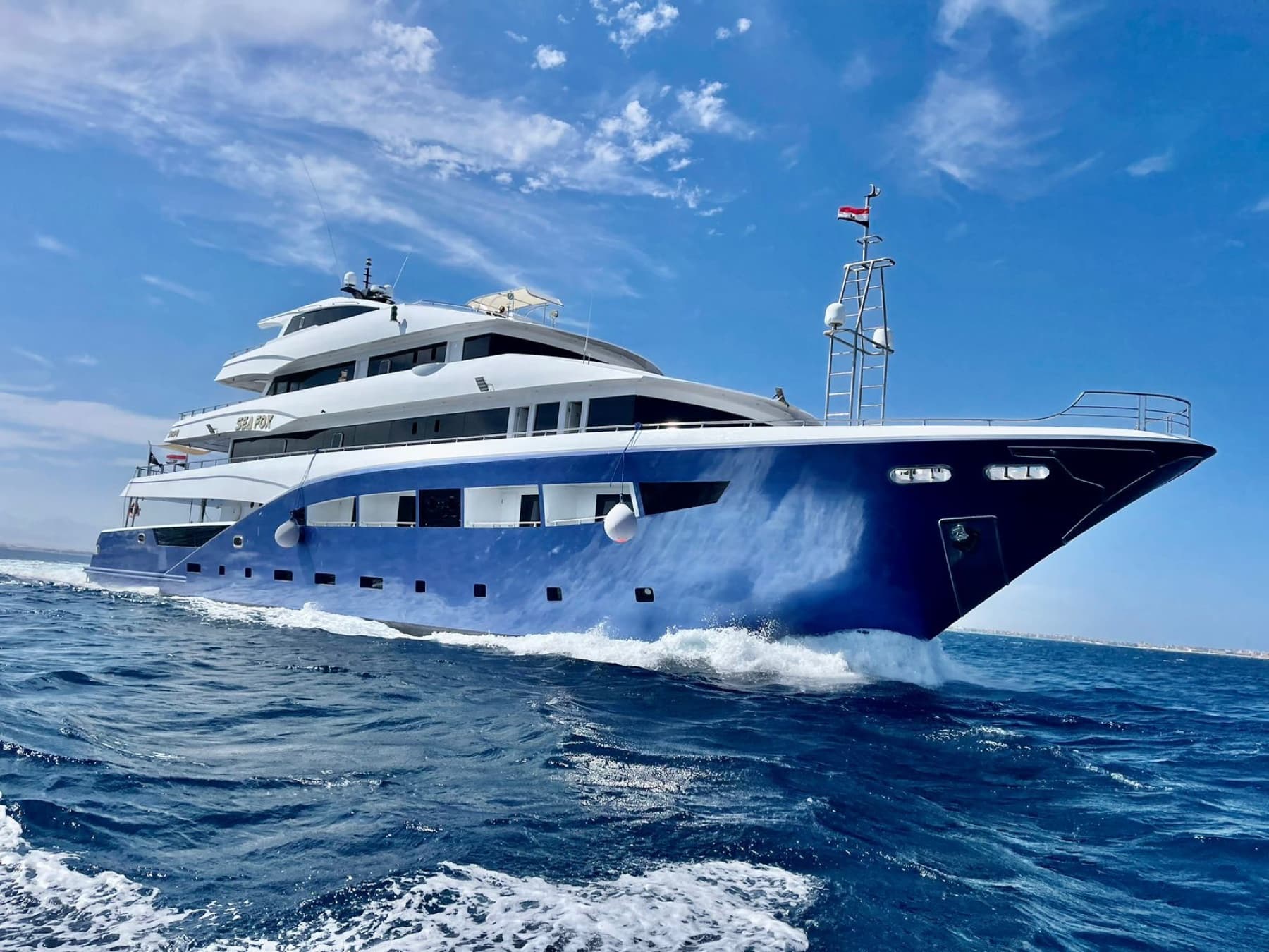Large blue-and-white yacht cruising off Hurghada